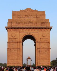 Front view of India Gate monument surrounded by visitors in New Delhi